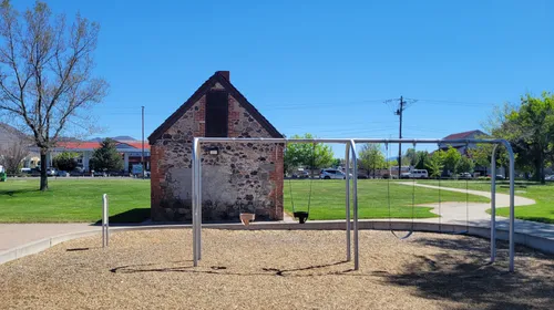 A historic stone building stands at the edge of the playground