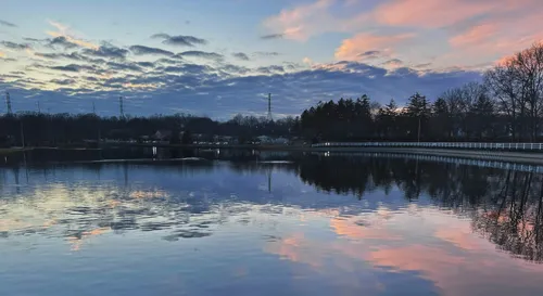 A calm evening at Roosevelt Park Lake reflecting pink and blue sunset clouds