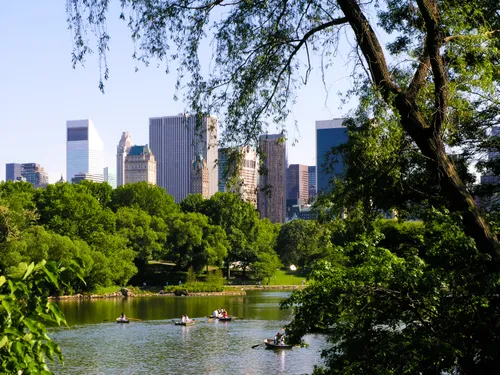 Lush greenery frames the south pond with Manhattan towers behind