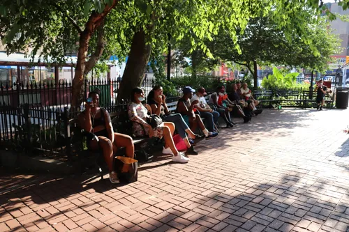 Visitors relaxing along the park's shaded brick pathway