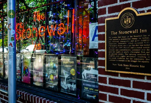 The Stonewall Inn's neon sign and historic landmark plaque