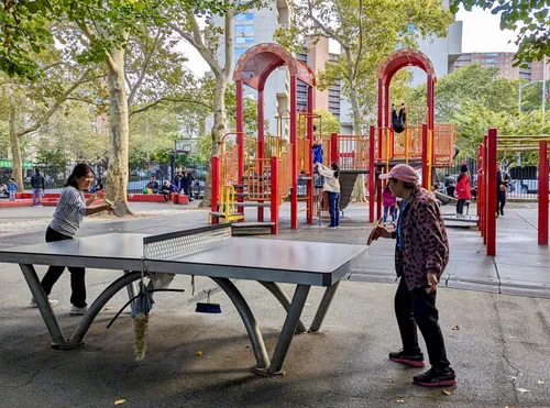 A casual ping pong match unfolds next to the playground