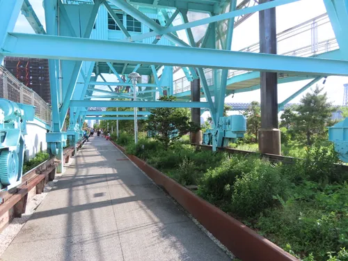 A walkway passes beneath the preserved industrial crane structures