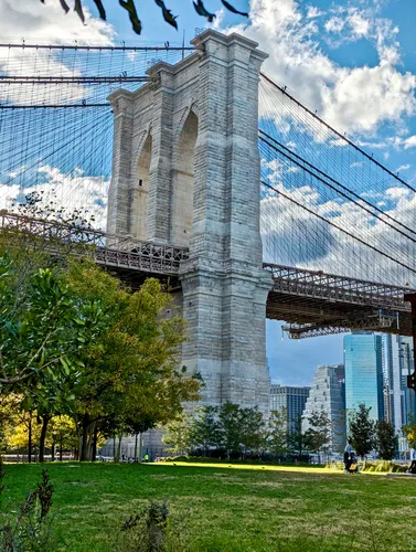 Looking up at one of the Brooklyn Bridge's iconic stone towers from the park below