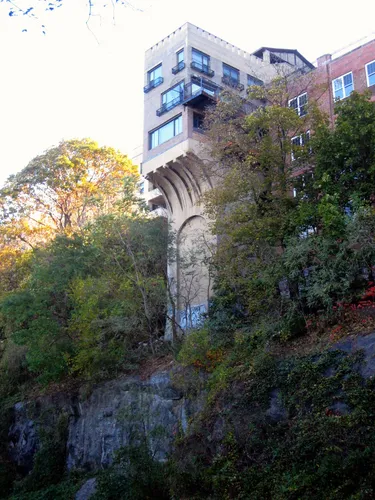 Narrow building nestled among foliage on the cliff