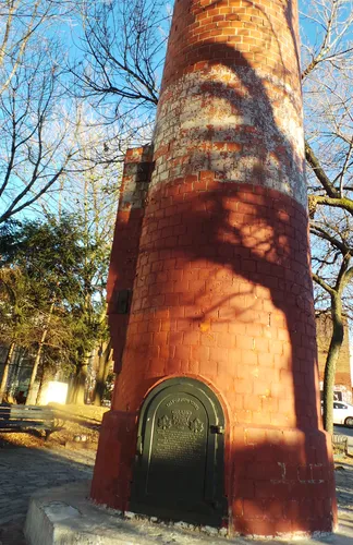 A red smokestack stands as an industrial relic in the waterfront park