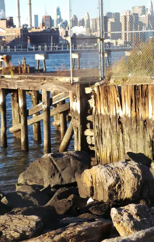 Weathered wooden pilings and the rocky shoreline at Grand Ferry Park