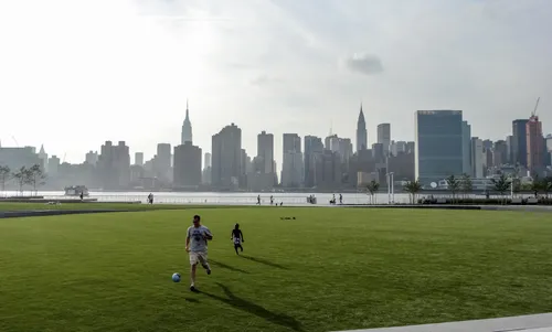 A father and child play soccer on the open lawn