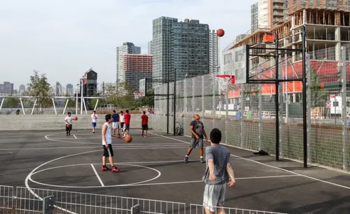 Basketball courts in active use with residential towers in the background