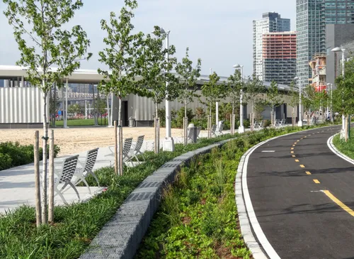 Lined with trees and seating, a paved cycle path curves along the park