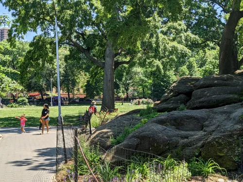 Pathway winding past large boulder formations on a sunny day