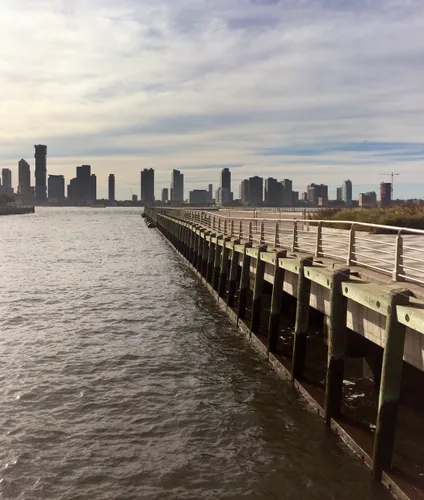 Long Pier 26 stretches toward Jersey City skyline along the Hudson River