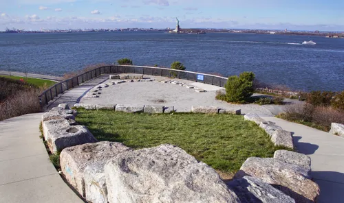 Stone-bordered lookout point with views of the Statue of Liberty