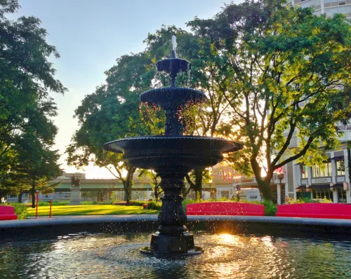 The park's tiered fountain catches the warm glow of the setting sun