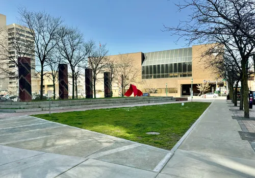 The brick colonnade and red sculpture add character to the park