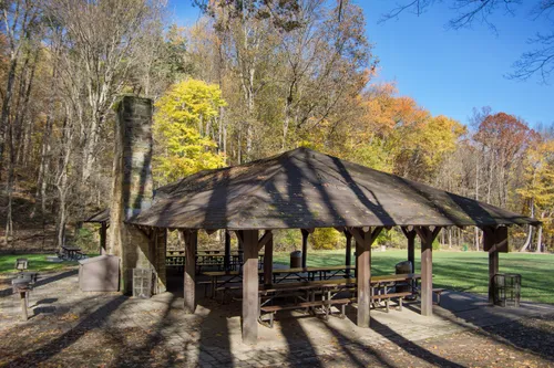 A shaded pavilion surrounded by autumn foliage