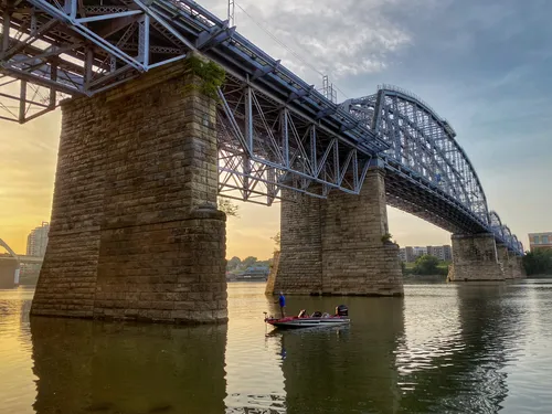 Purple People Bridge above tranquil waters during sunrise