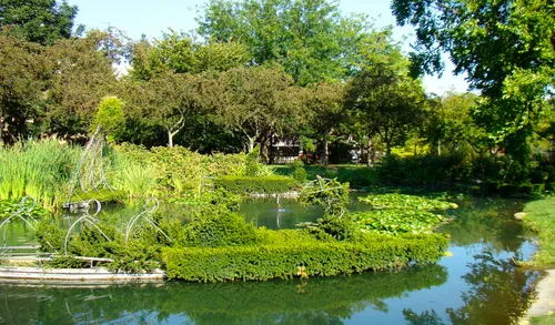 Serene pond with lush greenery reflecting the park's artistic theme