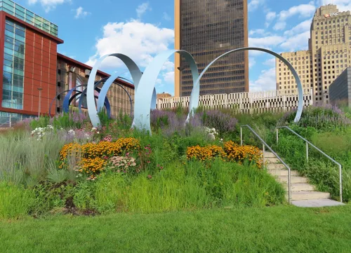 The eleven rings of the Echo sculpture sit in a native planting bed