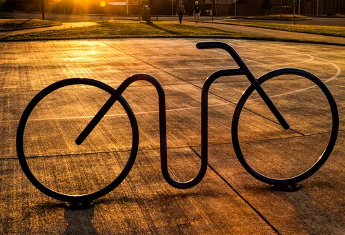 Bike rack at the edge of the park against the setting sun