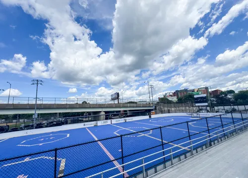 The blue dek hockey rink awaits players under a grand sky