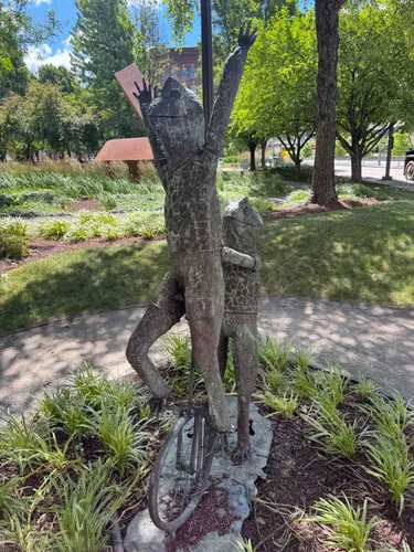 One of Albert Guibara's bronze frogs balances on a unicycle with arms outstretched