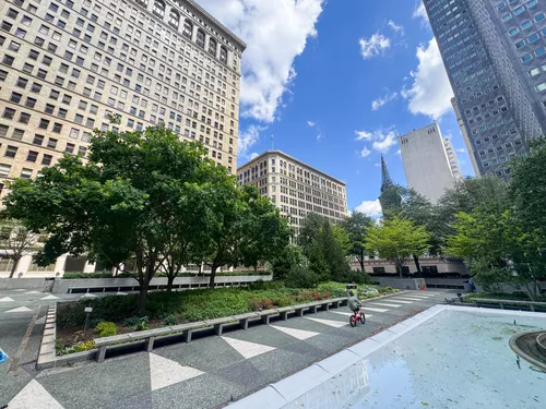 A kid rides a bike along the park's iconic geometric pavement