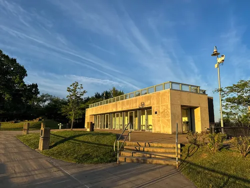 The Elmer Clark Pavilion sits in open green surroundings under a blue sky