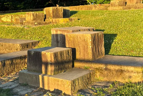 Tiered stone seating steps catch warm sunlight in the park