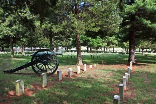 A cannon stands within the National Cemetery grounds