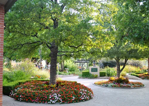 Circular flower beds surround trees in the Amarillo Botanical Gardens