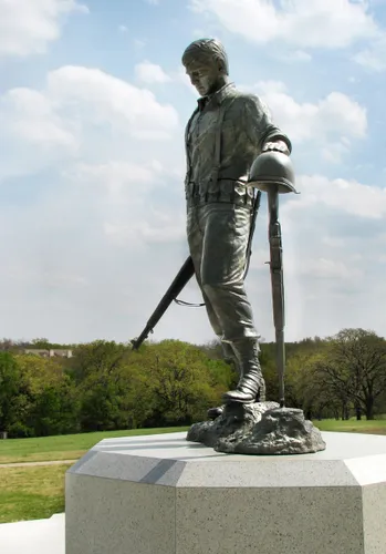 Bronze statue of a soldier stands atop a stone pedestal