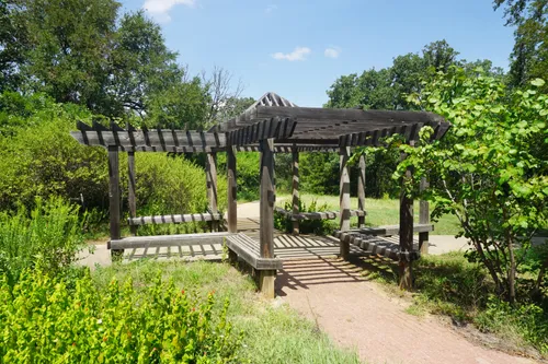 Wooden pergola offers a resting spot amid greenery