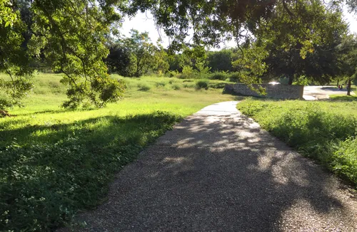 A pathway winds through the green landscape near the parking lot
