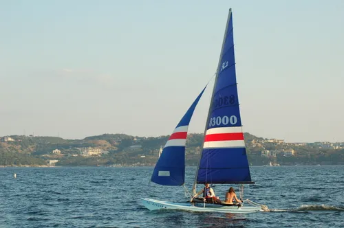 A sailboat glides across the water on a clear day