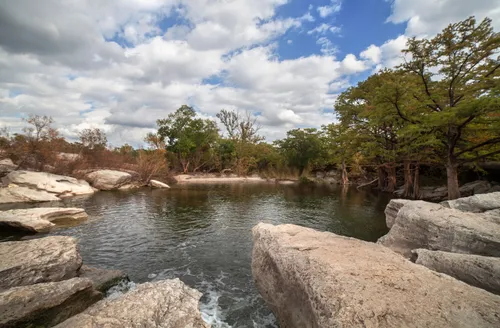 Rocky shoreline frames the waters of Onion Creek