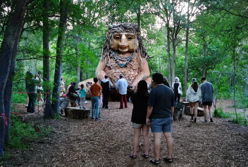 Visitors meeting Malin the troll, an adorable sculpture located in the forest