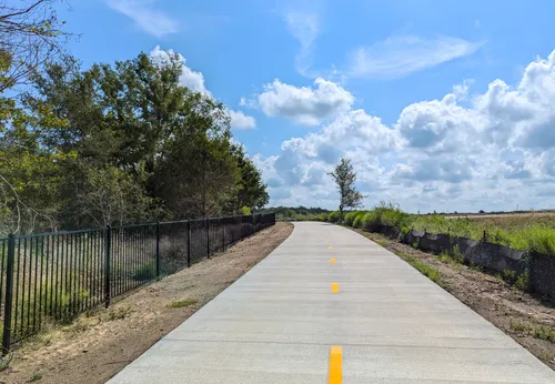 A bike trail stretches through the north section of the park on a sunny day