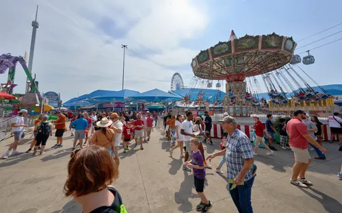 Fairgoers near the traditional swing carousel ride