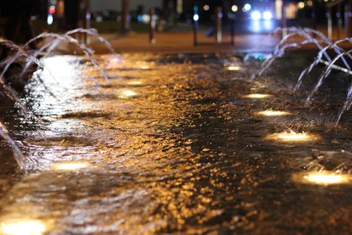 Evening water feature illuminated by warm ground lighting