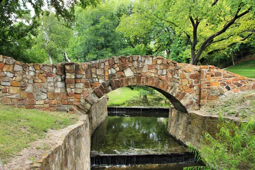 Historic stone bridge arching over Turtle Creek