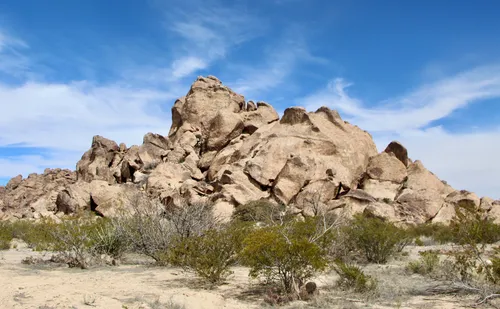 Large granite boulder formations rise above the desert scrub