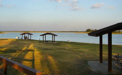 Picnic shelters overlook the grassy shoreline of Lewisville Lake