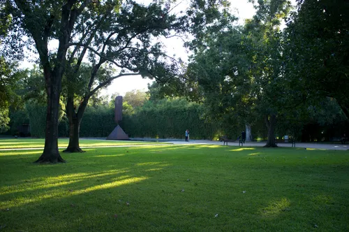 Lush lawn and mature trees create serene spaces between art installations