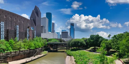 Buffalo Bayou winds through the park with skyscrapers behind