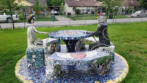 Whimsical mosaic figures sitting on benches