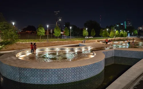 Tiled fountain pools along San Pedro Creek lit up after dark