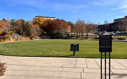 The large open green lawn at the park on a clear autumn day