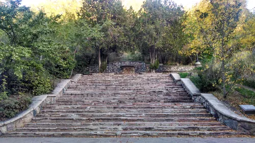 Wide stone steps lead up toward a switchback path through the trees