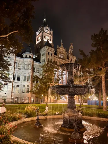 City-County Building illuminated at night with fountain in foreground